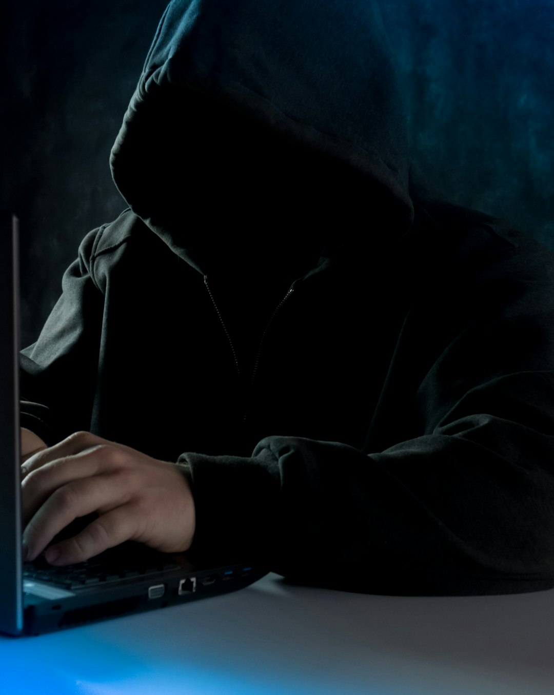 A Man In A Hoodie Using A Laptop Computer Bcrm2e1m0a4
